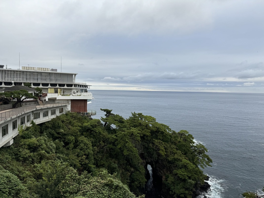 海沿いに建つホテルと、緑が茂る岬が広がる風景